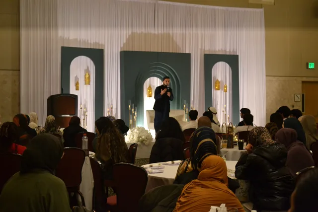 A speaker addressing seated attendees at Speakers’ Night