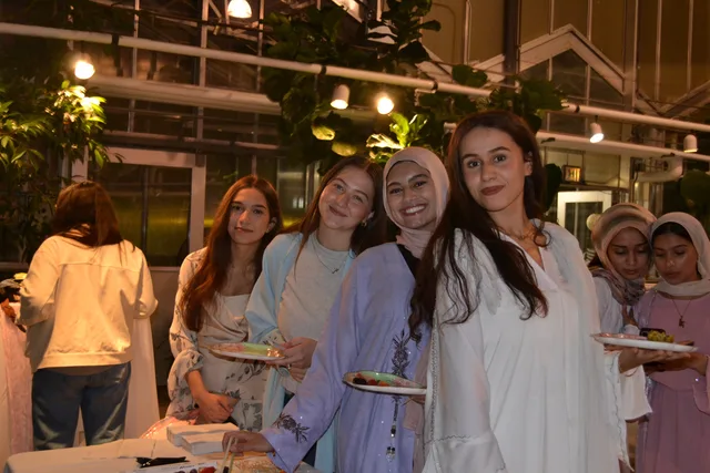 Four attendees beside the greenhouse food table