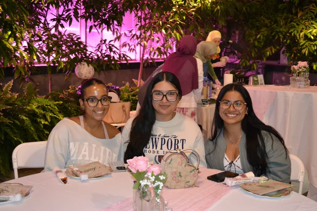 Three attendees seated at a decorated table