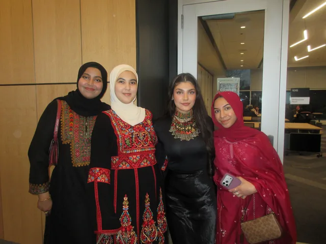 Four attendees posing in embroidered outfits